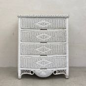 A vintage white painted wicker serpentine fronted chest of four long drawers with a shaped