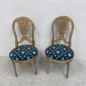 A pair of Louis XVI style gilt framed balloon back chairs each having a Neoclassical openwork