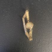 A vintage ladies Baume wristwatch in a 9ct gold case with a ladder style rolled gold strap.