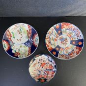 Three 19th century and later Japanese Imari plates each hand decorated with panels of red, blue