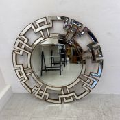 A large contemporary wall mirror having a circular bevelled plate in a gilt framed mirrored greek