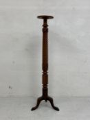 An early 20th century mahogany torchere or plant stand having a circular top over a carved twist