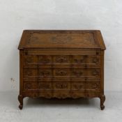 A 19th century French oak secretaire or writing bureau having a carved fall front opening to