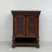 A 19th century Flemish walnut cabinet having top with fluted frieze drawer over a pair of carved and