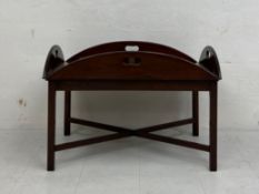 A large 19th century mahogany butler's tray table in two parts having an oval top with hinged