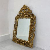 A 19th century Florentine style carved giltwood wall mirror having a rectangular plate below an