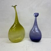 Two contemporary shaped coloured glass bottles. H.52cm (tallest)
