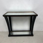 A contemporary ebonised Empire style console table with faux aged glass to the top and undertier.
