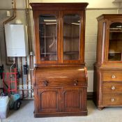 A late 19th century mahogany bureau bookcase with cylinder desk in two parts having a moulded
