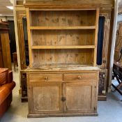 A 19th century pine dresser in two parts having a moulded cornice above three open shelves over a
