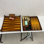 A backgammon board and counters along with a fitted chess, cribbage and backgammon set. 55x55cm (