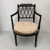 A Regency armchair having a shaped and carved black painted back with a latticework splat and out-