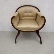 An early 20th century mahogany framed armchair having a marquetry inlaid top-rail with scrolled
