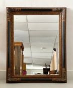 A contemporary ebonised and gilt 19th century style wall mirror with bevelled plate. 124x99cm