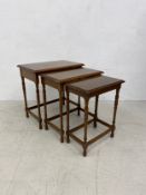 A 19th century style nest of mahogany graduating occasional tables on turned stretchered supports.
