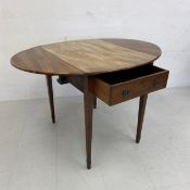 A 19th century mahogany drop leaf table having a circular top over a single frieze drawer raised