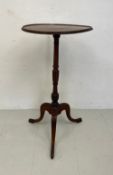 A 19th century mahogany occasional table having an oval top with a carved edge over a turned and