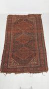 A hand knotted Persian style Shiraz carpet having three central diamond lozenge medallions in iron