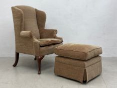 A Georgian style wingback armchair on mahogany cabriole supports along with the matching
