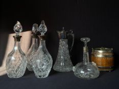 A mixed collection of five cut glass decanters with hallmarked silver collars to include a figural