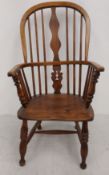 A 19th century elm Windsor hooped back armchair with shaped splat above saddle seat on turned