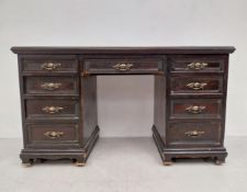 A late 19th century carved walnut pedestal desk with an arrangement of nine drawers on ogee