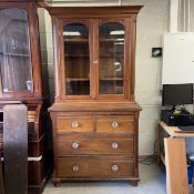 A 19th century walnut bookcase in two parts having a moulded cornice over a pair of glazed cabinet