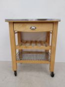 A contemporary beech butcher's block style kitchen table having a square metal mounted top over a