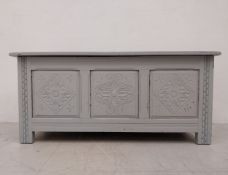 A Jacobean style coffer with carved panels on stile supports, later painted. H.51. W.102 D.45cm
