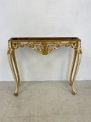 A painted and gilt Rococo carved console table on cabriole supports. 87x101x30cm. (Lacks it's top as