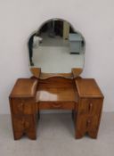 A mid century Art Deco style figured walnut dressing table with shaped adjustable plate above sunken
