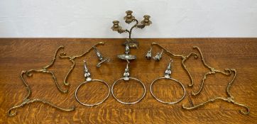 A brass candelabra and six unusual brass coat hangers along with chrome wall bathroom fittings.