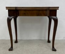 A mid 18th century walnut fold-over card table with tooled leather inset top and sunken counter