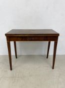 A Georgian mahogany tea table with foldover gate-leg action on square section tapering supports.