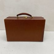A 1940s pigskin travel vanity case in two fold out sections with brass lock and catch enclosing a