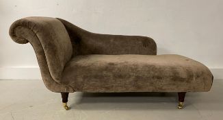 A chaise longue in the late 19th century style having a scrolled back and shaped arm over a