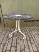 A wrought iron framed garden or conservatory table with teak sunburst top on scrolling tripod