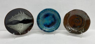 Three mid 20th century studio pottery plates. Dia.28cm