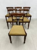 A set of six Regency rosewood bar back dining chairs with drop in seats on caned bases raised on