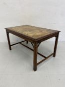 A Georgian style mahogany coffee table having a gilt and tooled green leather top with a thumb