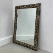 A contemporary wall mirror having a rectangular plate in a gilt scrolling foliate frame. H.107 W.