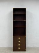 A vintage mahogany campaign style open bookshelf having four shelves over four short drawers with