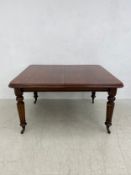 A mid 19th century mahogany dining table with two extra leaves and wind-out mechanism raised on