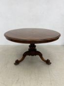 A Victorian rosewood breakfast table with tilt top action on carved tripod pedestal base. 73xDia.