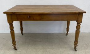 A 19th century fruitwood kitchen table fitted with frieze drawer on turned tapering supports.