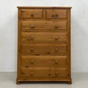 A contemporary 19th century pine tall chest of two short over five long drawers on squat bun feet.