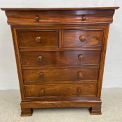 A Victorian style teak chest of drawers with frieze drawer above two short and three long drawers on