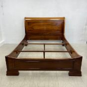 A figured hardwood sleigh bed in the 19th century Continental style. For a mattress up to 5'3
