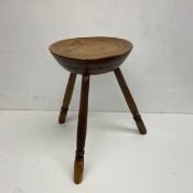 A 19th century pine three legged stool. H.43cm