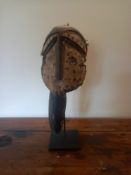 A carved and painted Kwele tribal mask on stand. H.36cm
